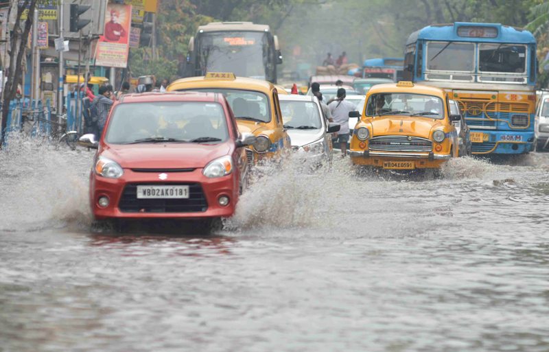 Rickshaw puller wades through water-logged street in Kolkata