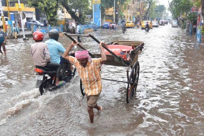 Rickshaw puller wades through water-logged street in Kolkata