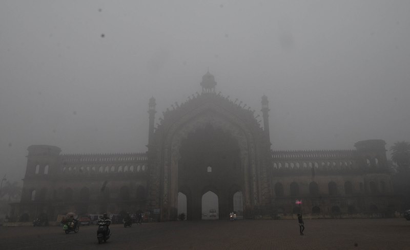 A man cycles in a fog covered morning in Lucknow