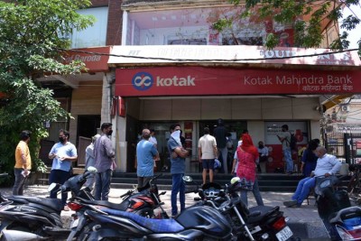 Customers maintain social distancing outside bank in New Delhi