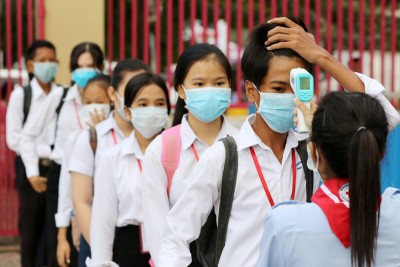 Students queue for body temperature screening at the Bak Touk High School in Phnom Penh