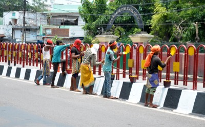 Labourer painting divider on a road as Lucknow preps up for Prez's arrival