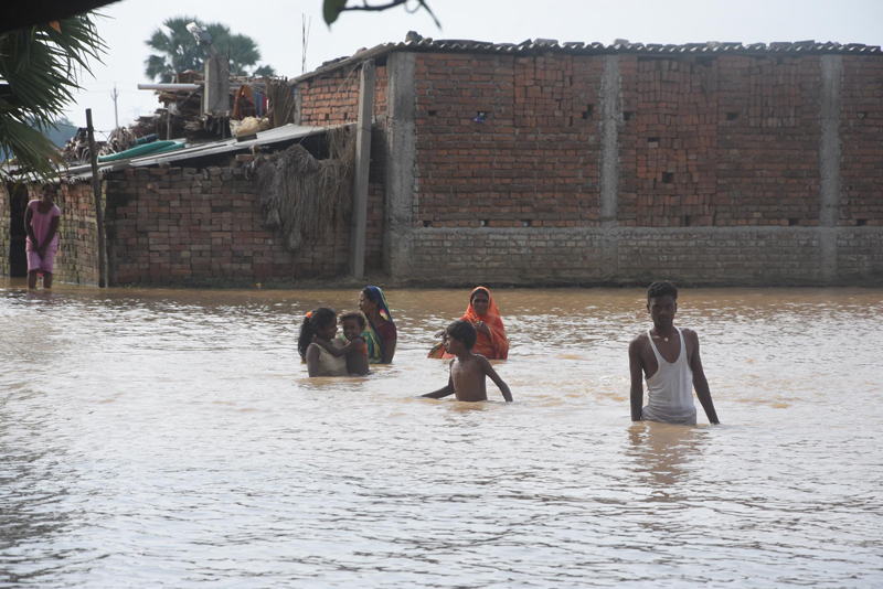 People braving floodwaters in a village near Patna