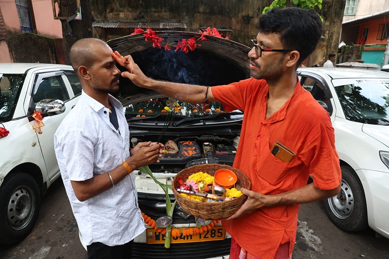 Priest offers prayers to taxi during Vishwakarma Puja in Kolkata