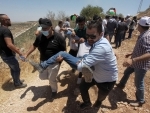 Palestinian protesters carry an injured man during clashes with Israeli soldiers