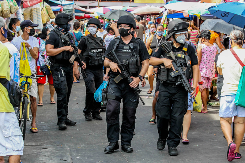 Members of the Special Weapons and Tactics of the Philippine National Police (PNP-SWAT) patrol a market