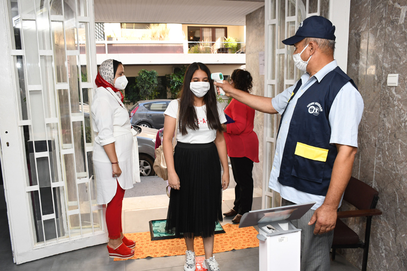 Morocco: Student wearing a mask has her temperature checked before attending a class in school